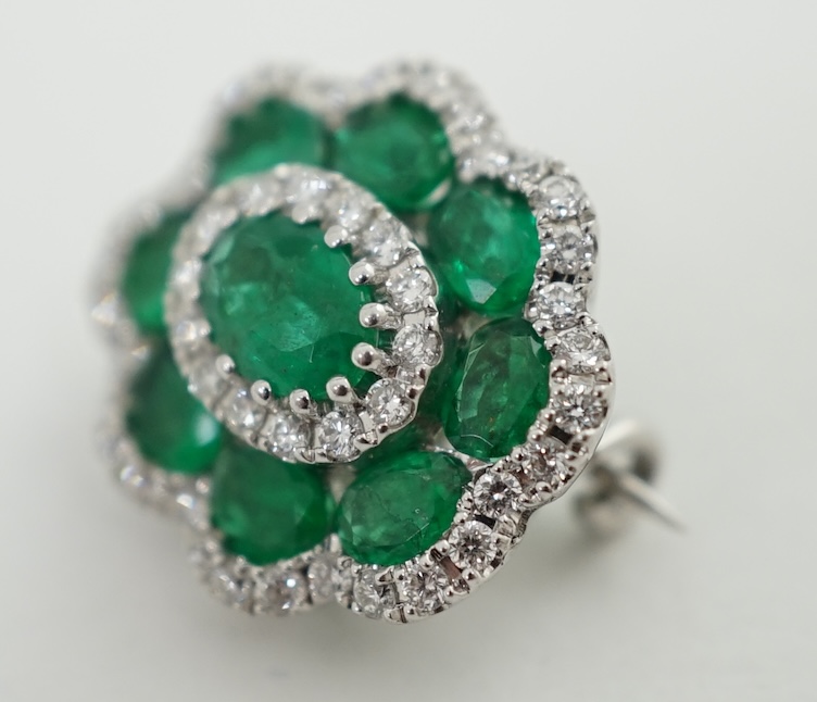 A mid to late 20th century white gold, emerald and diamond cluster set brooch